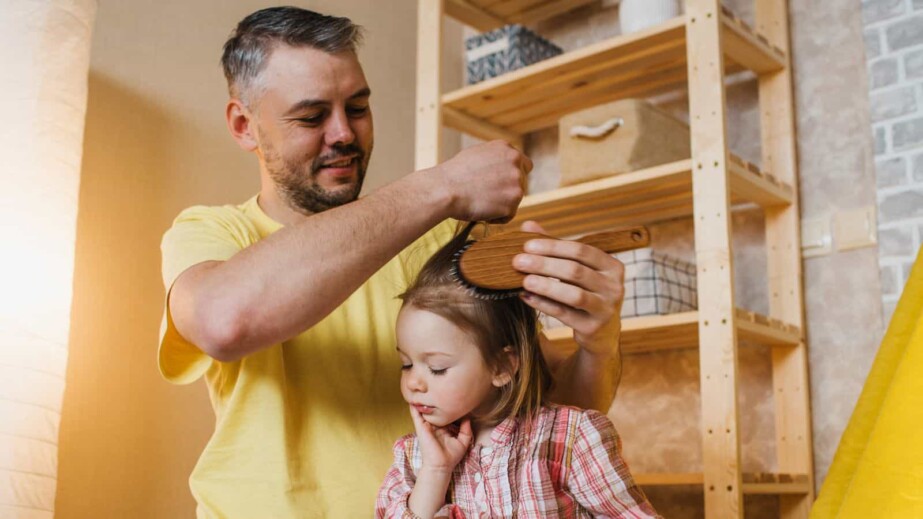 father combing daughter's hair