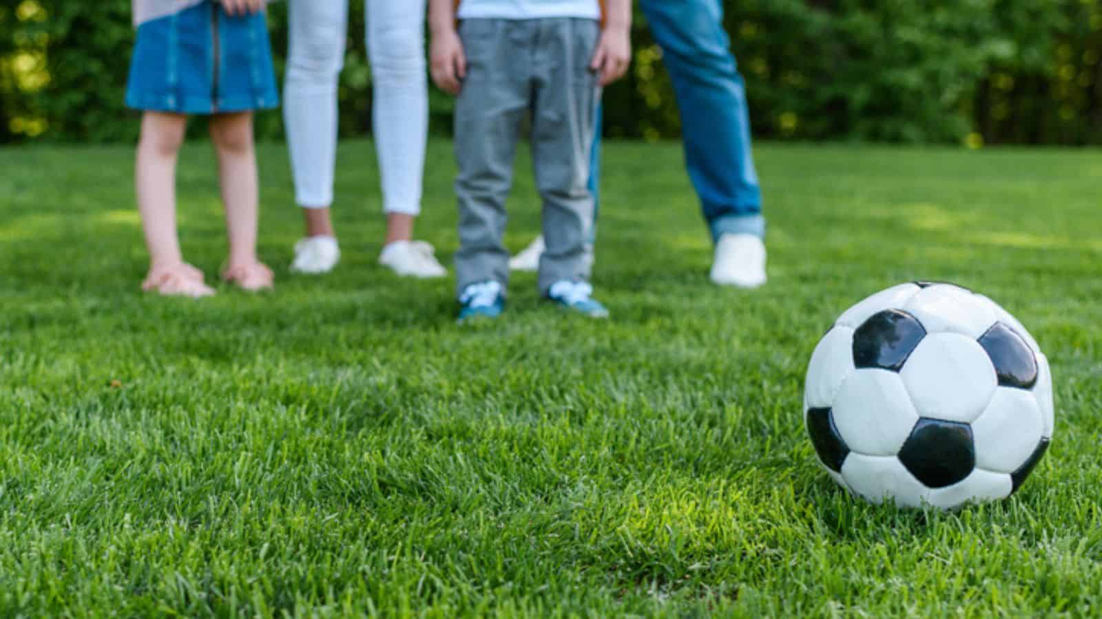 Cropped shot of family standing together and soccer ball