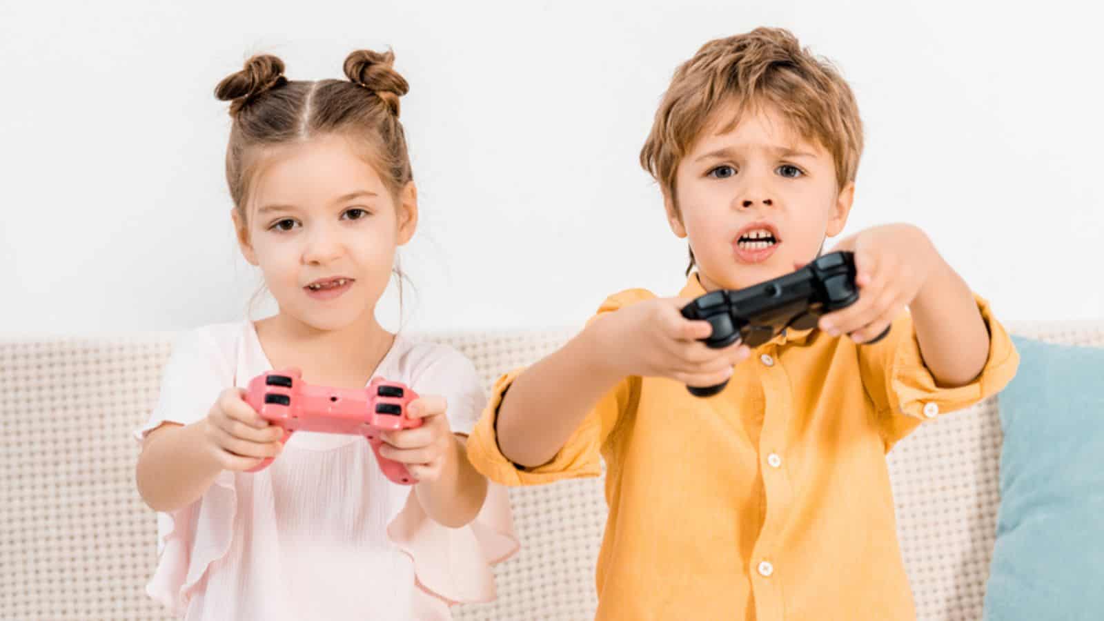 Adorable kids playing with joysticks and looking at camera