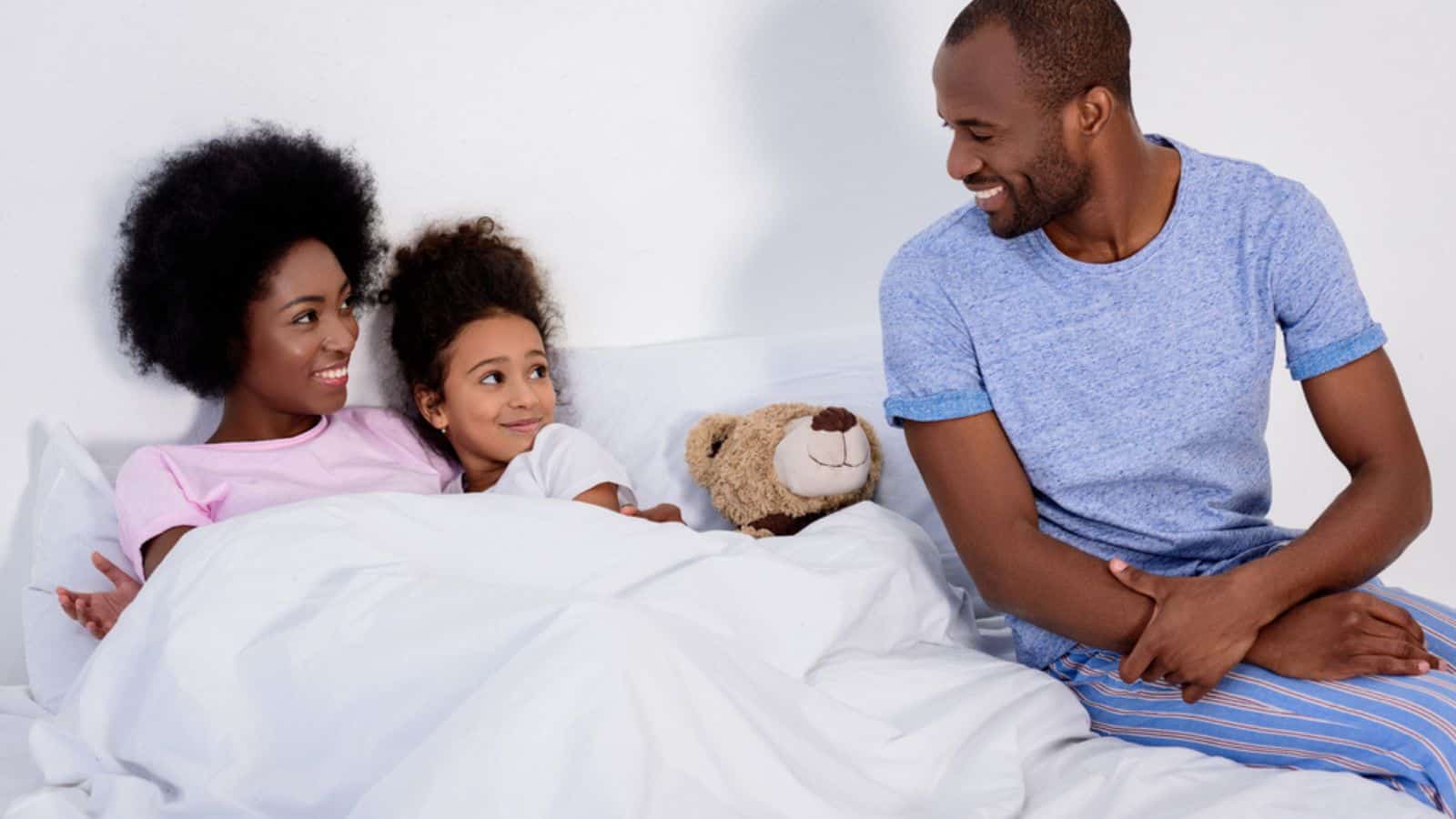 African american parents and daughter in bedroom looking at each other