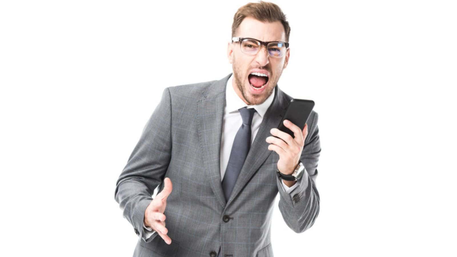 Angry adult businessman shouting at smartphone