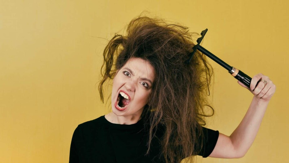 Annoyed Woman brushing her messy hair