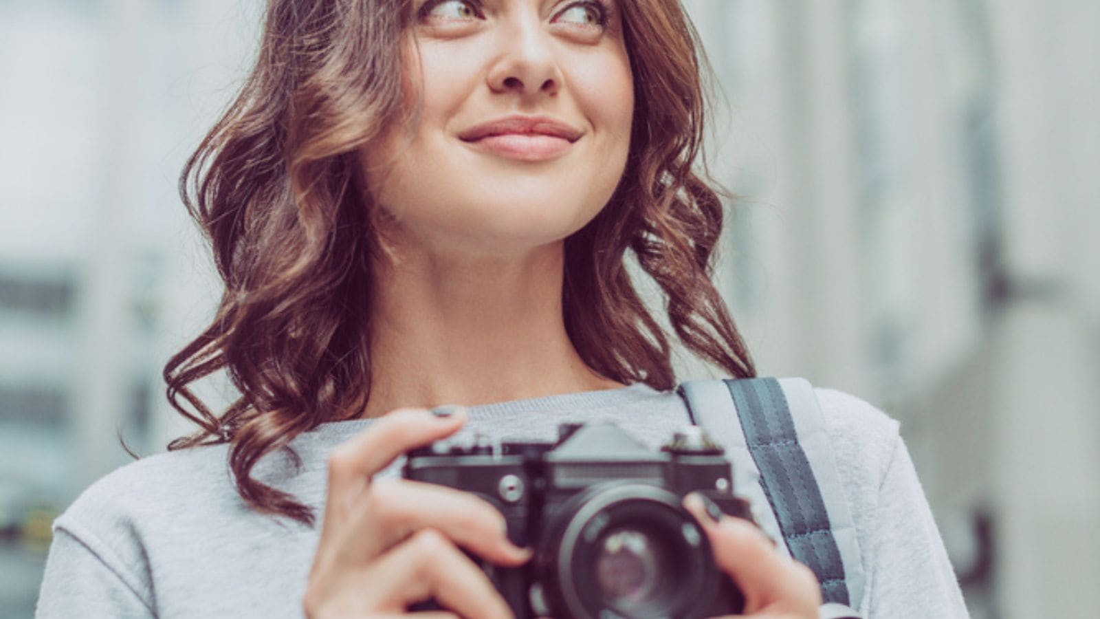 Attractive brunette woman with photo camera in city