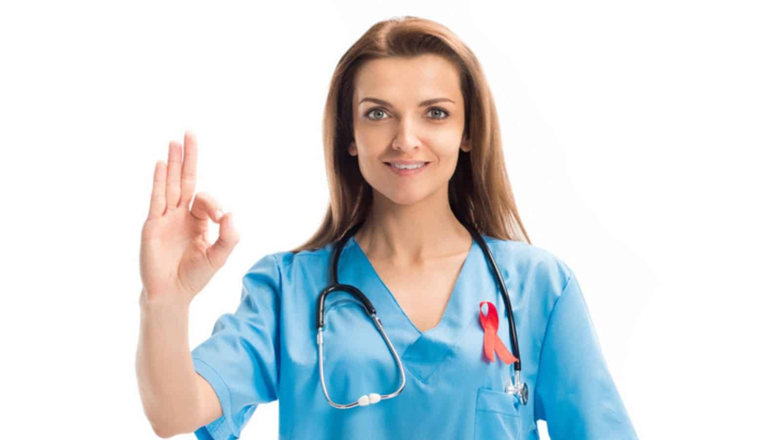 Attractive doctor with red ribbon showing okay gesture