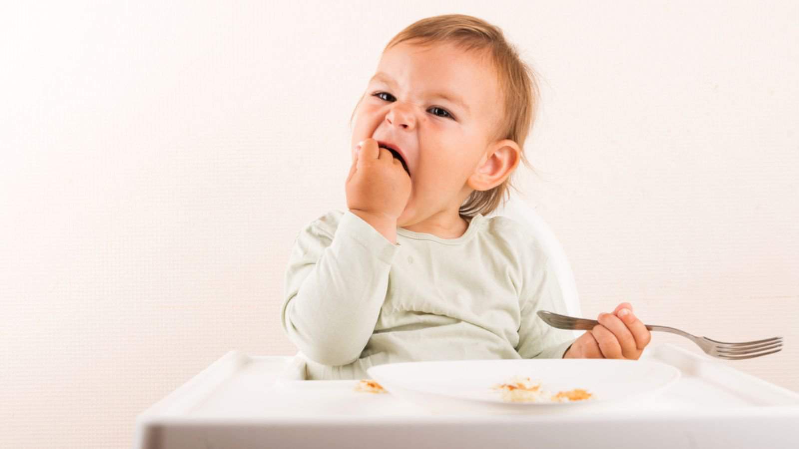 Baby toddler eating pancakes with fork