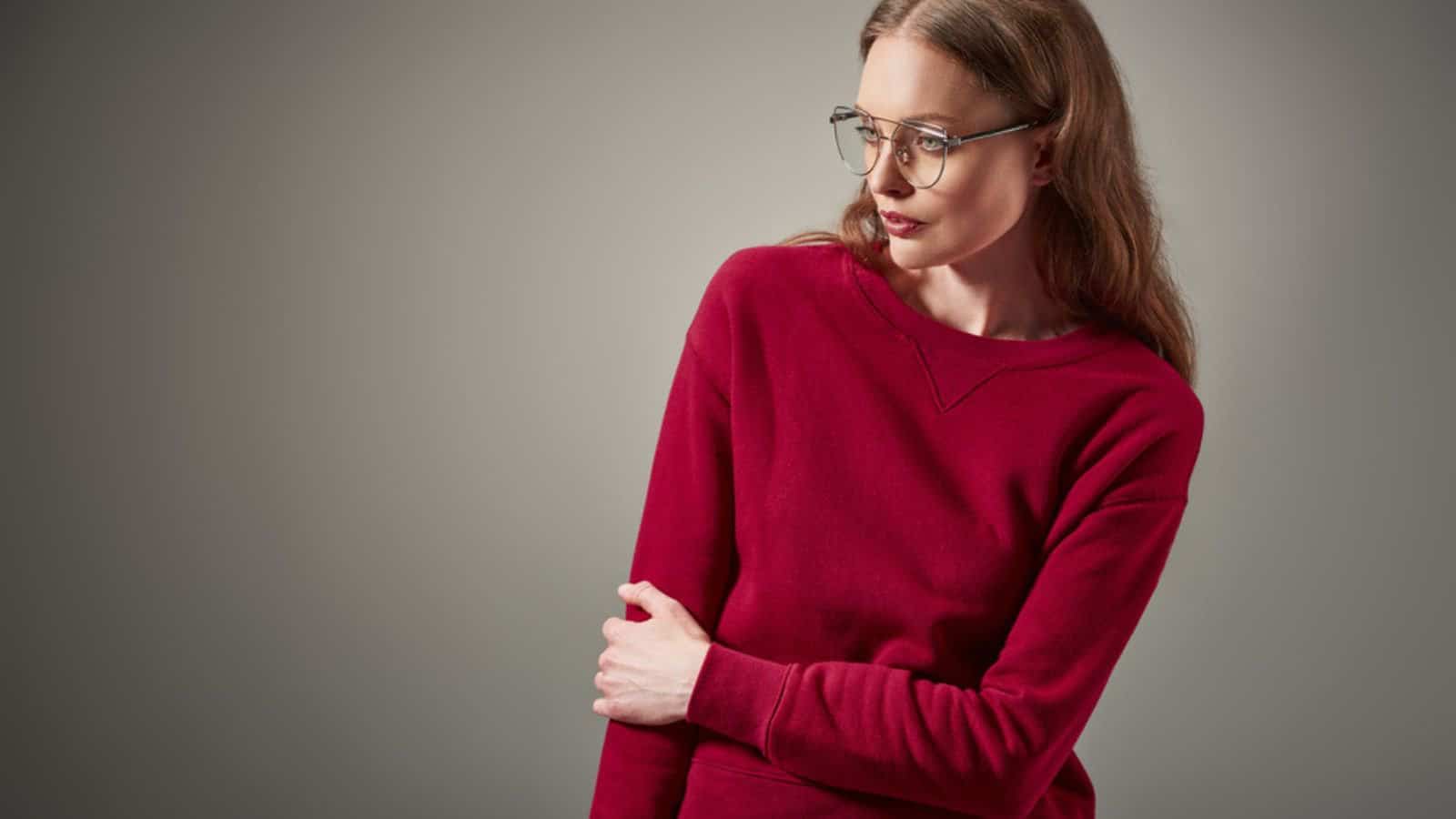 Beautiful woman in stylish outfit and eyeglasses looking away