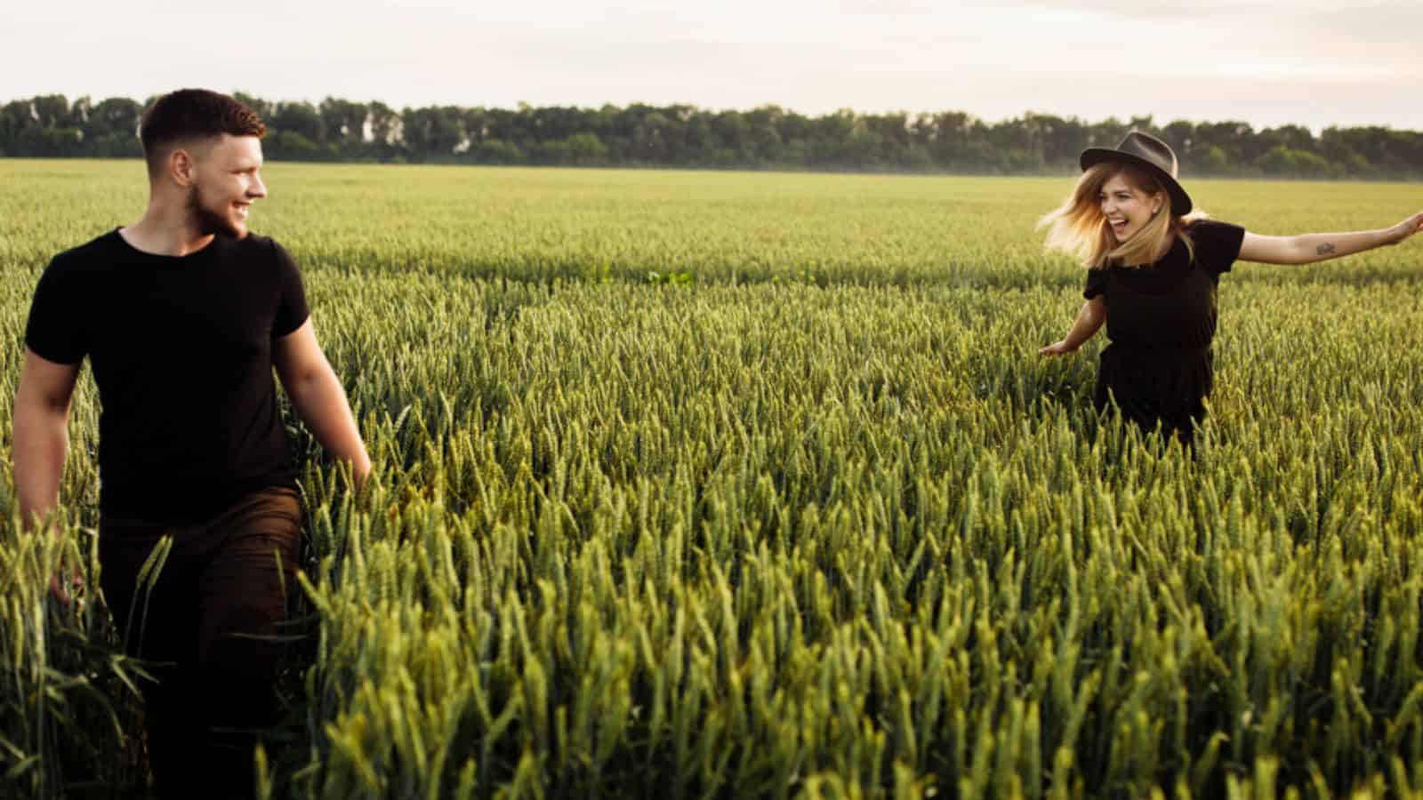 Beautiful young couple walking on wheat field