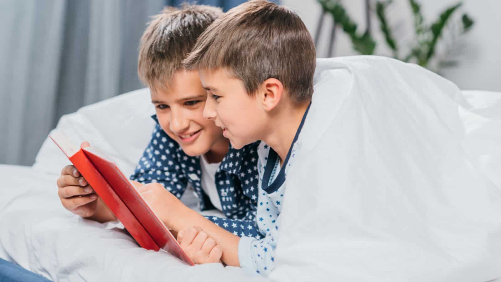 Boys reading book together