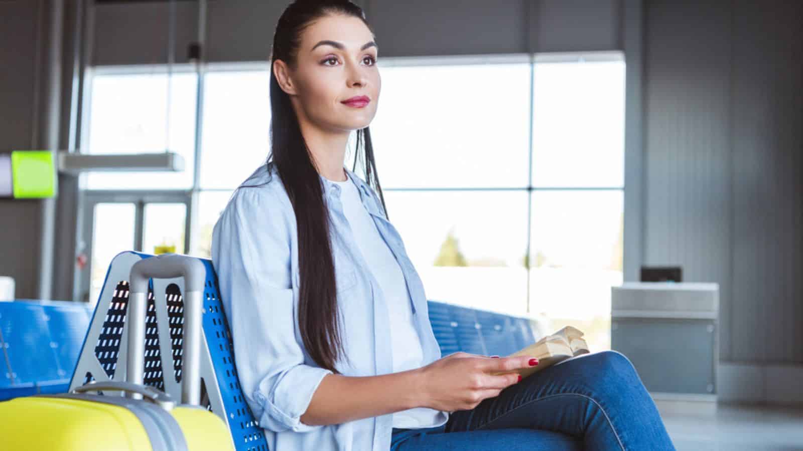 Brunette woman with book sitting in the airport