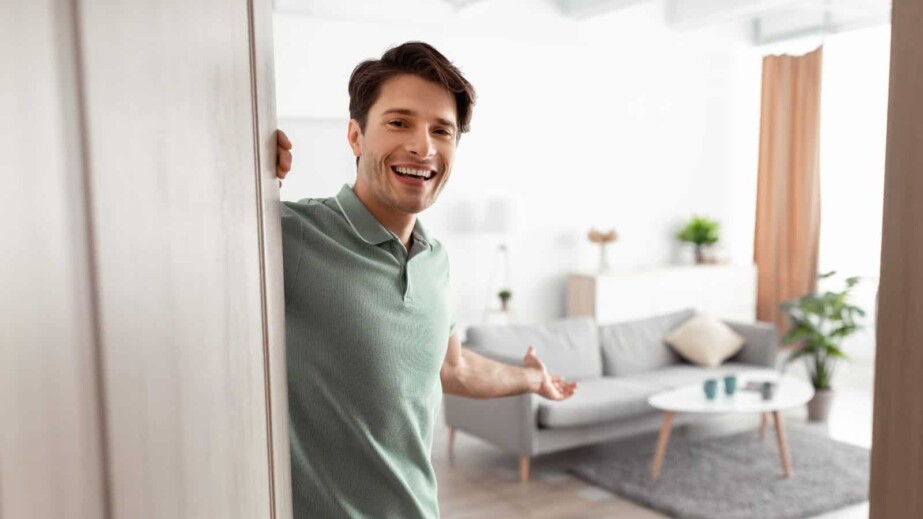 Cheerful Guy Inviting People to Enter Home