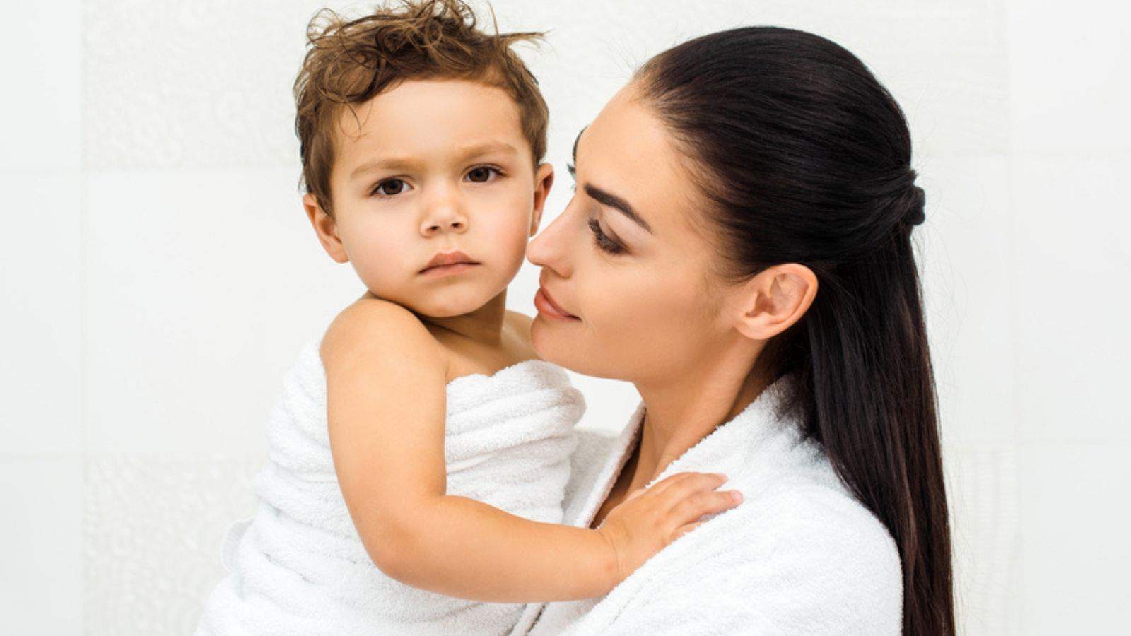 Close up of mother looking at toddler son in towel