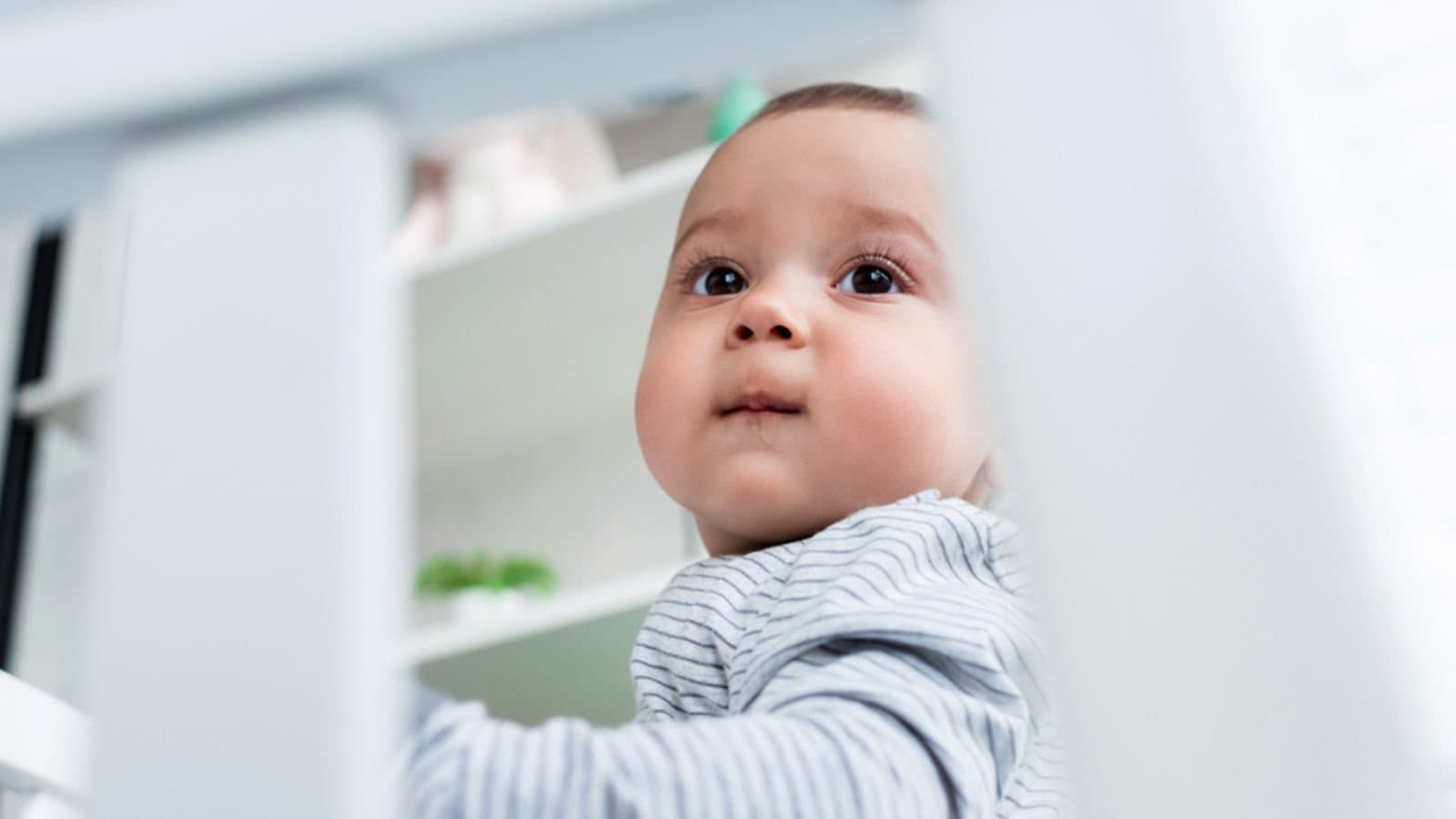 Close-up portrait of adorable little child in baby cot