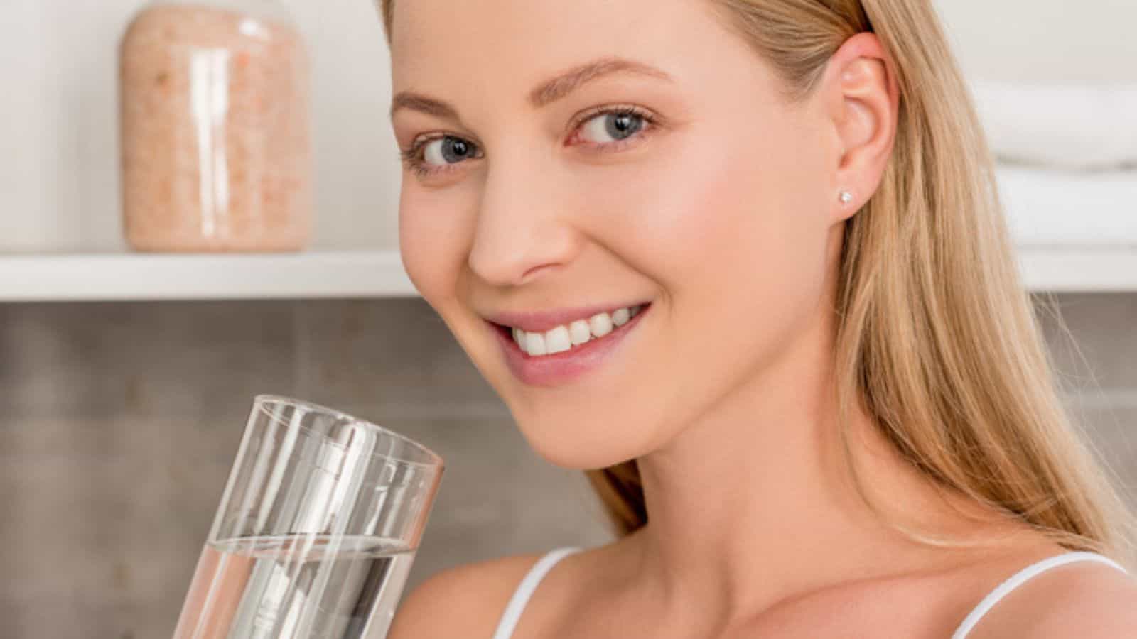 Close-up portrait of pregnant woman with glass of water