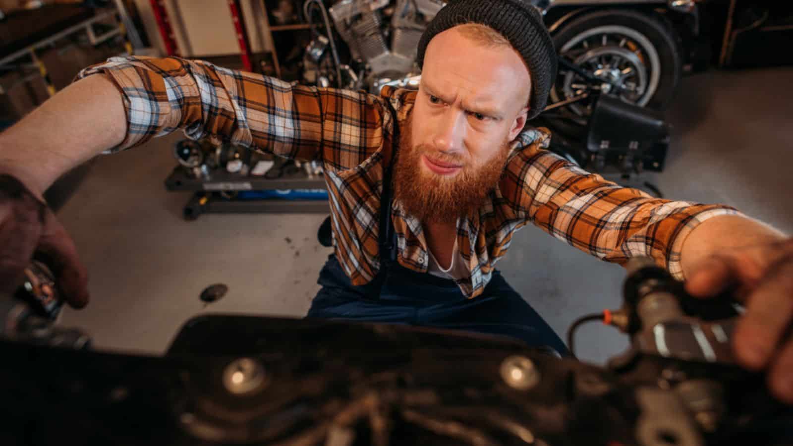 Close-up shot of bike repair station worker fixing motorcycle