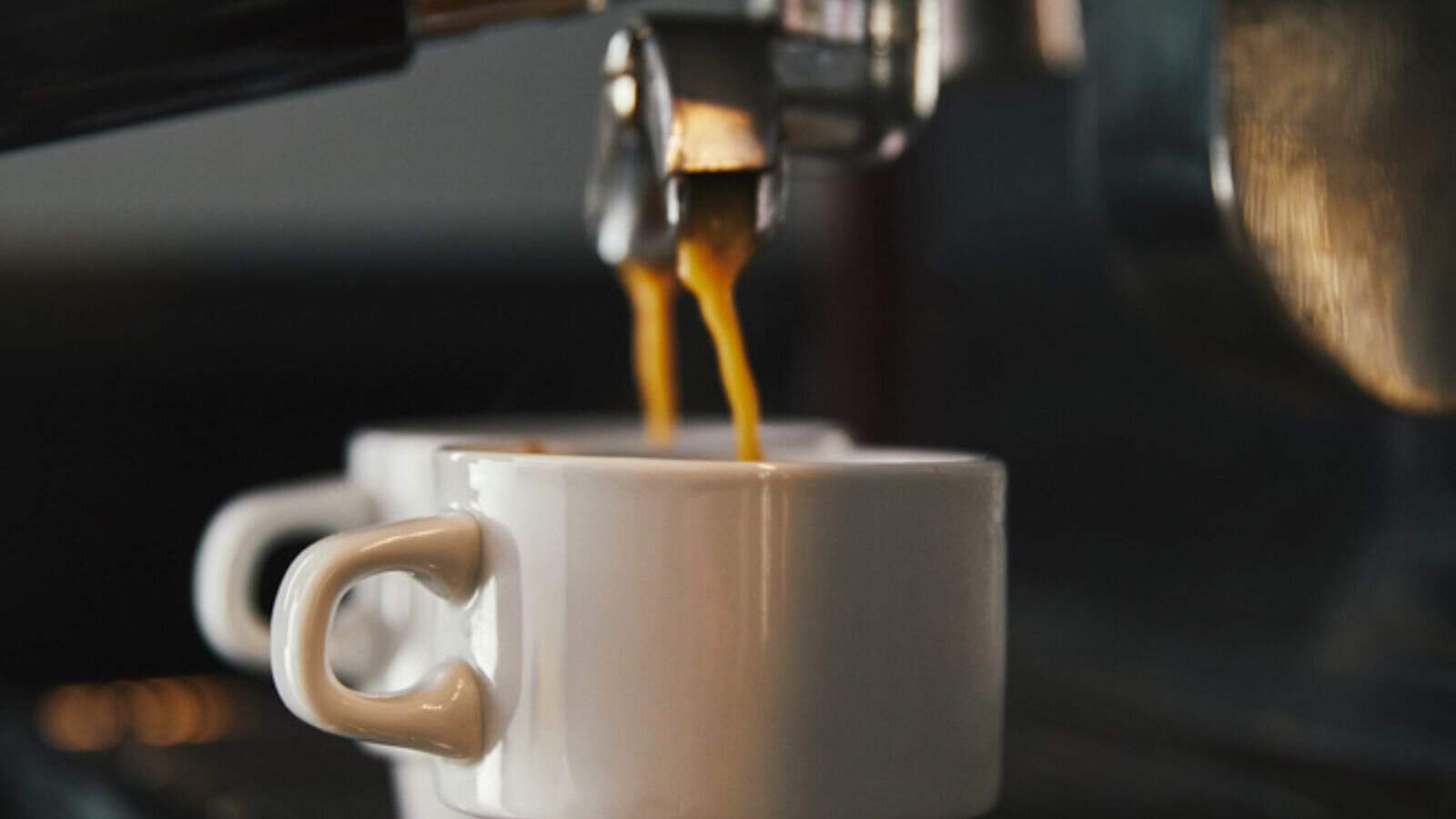 Close-up view of coffee machine and two cups with espresso