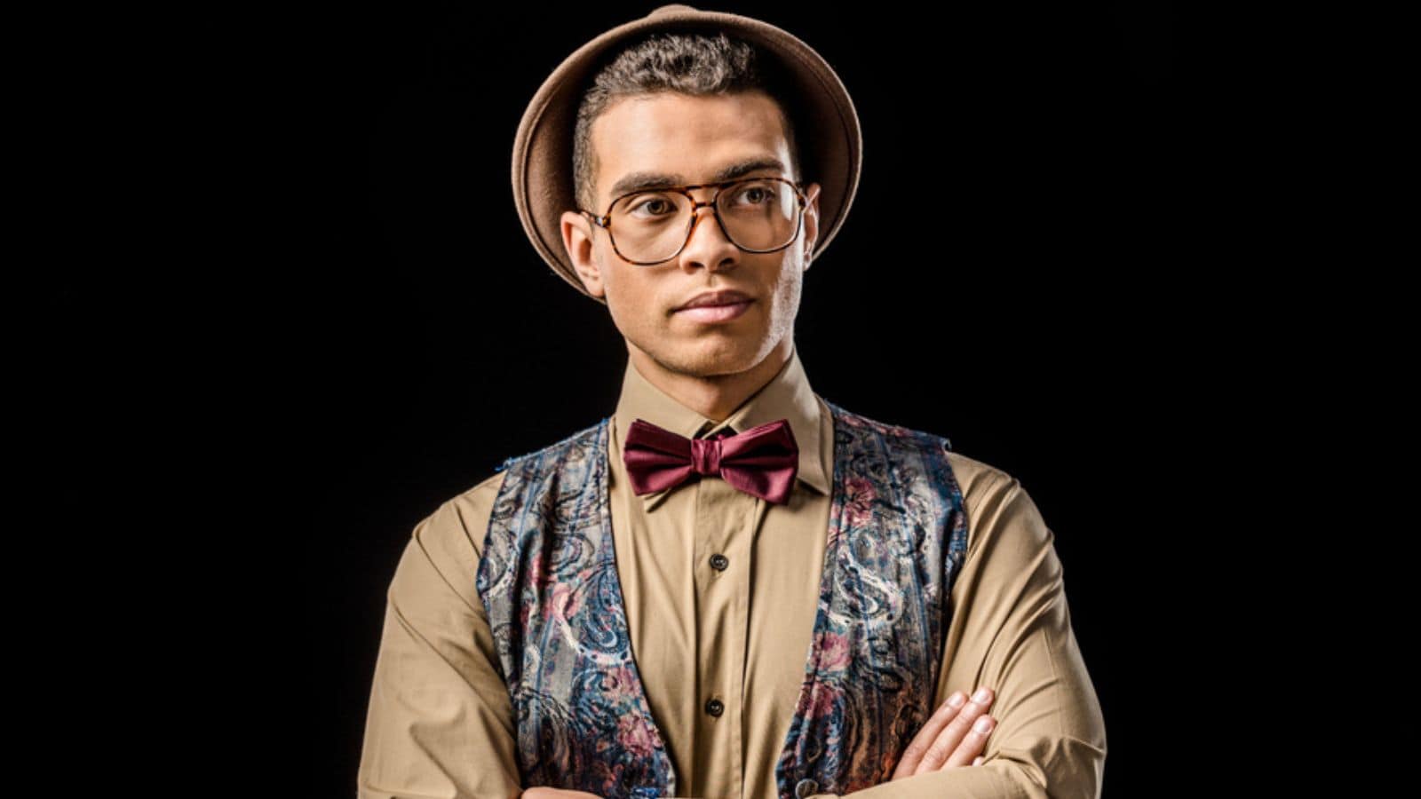 Confident young male model in vest and bow tie posing