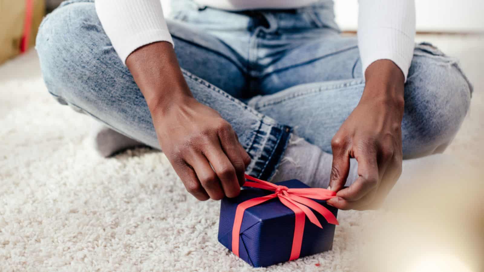 Cropped image of african american woman tying christmas gift