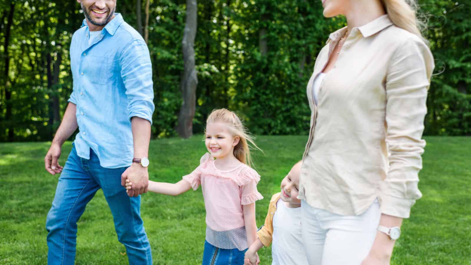 Cropped shot of happy family holding hands and walking