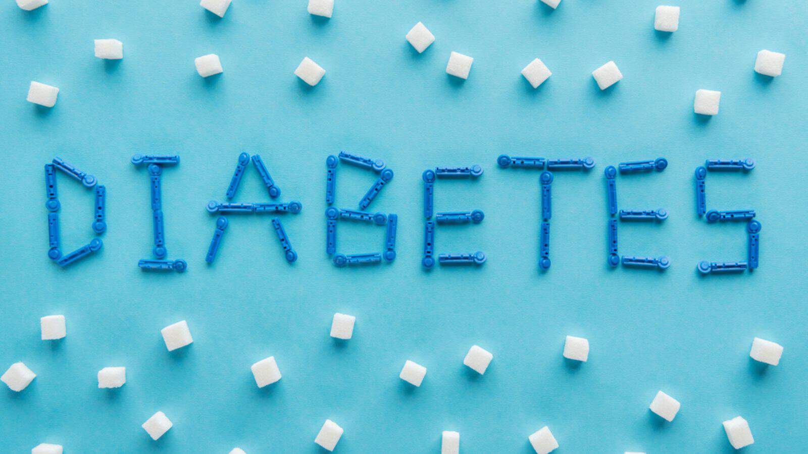"Diabetes" word made of disposable needles with sugar cubes