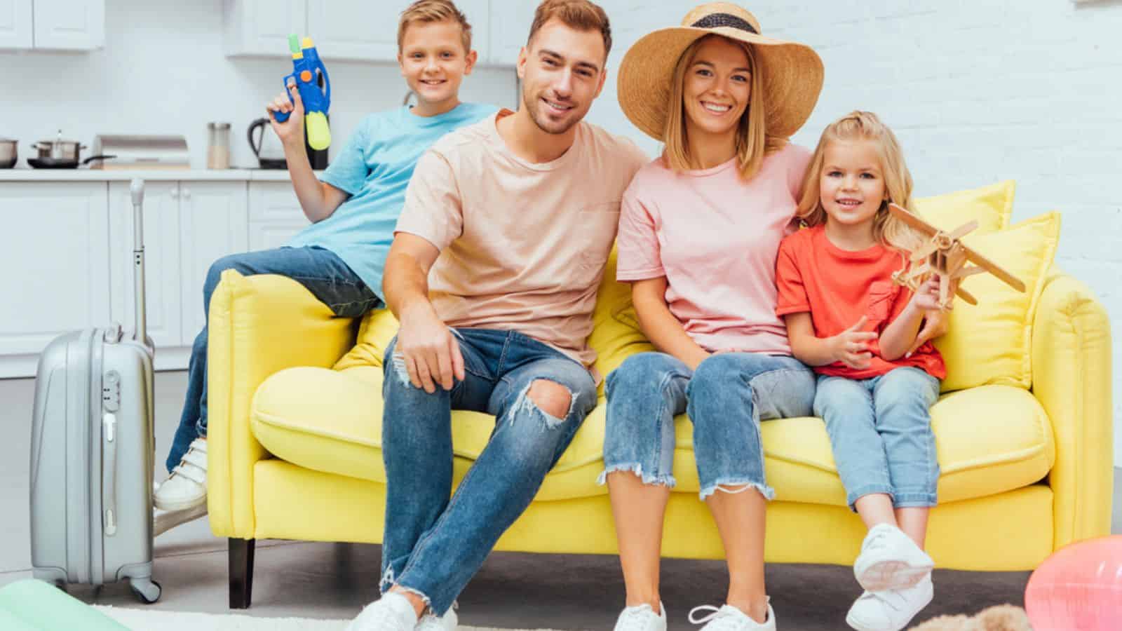 Family resting on sofa after packing for summer vacation, travel concept