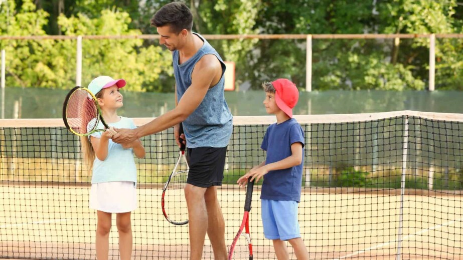 Father teaching his kids tennis