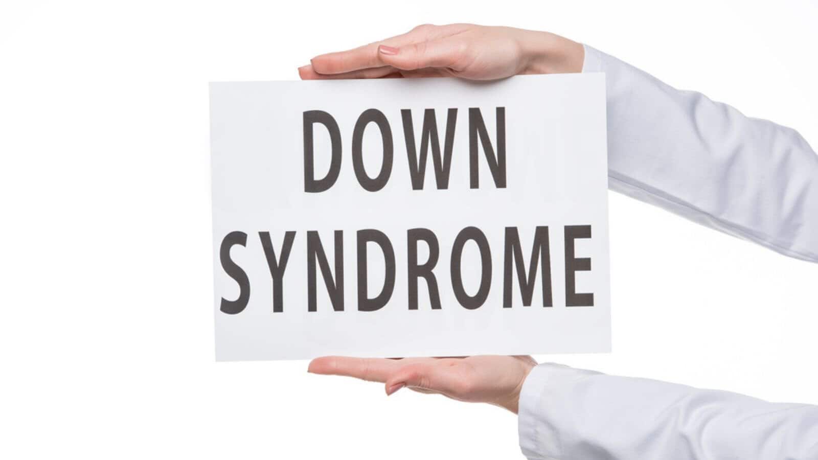 Female hands holding sign with Down Syndrome text