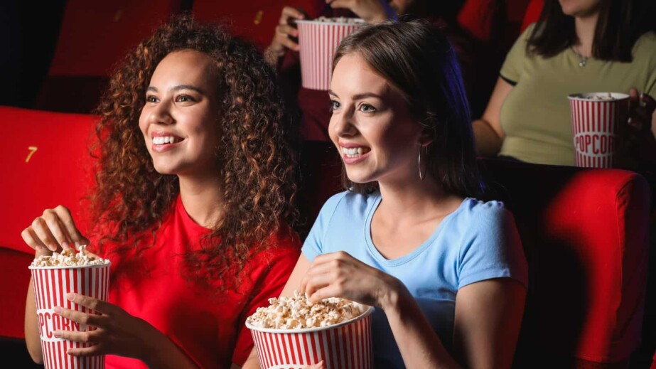 Friends with Popcorn watching movie in cinema 