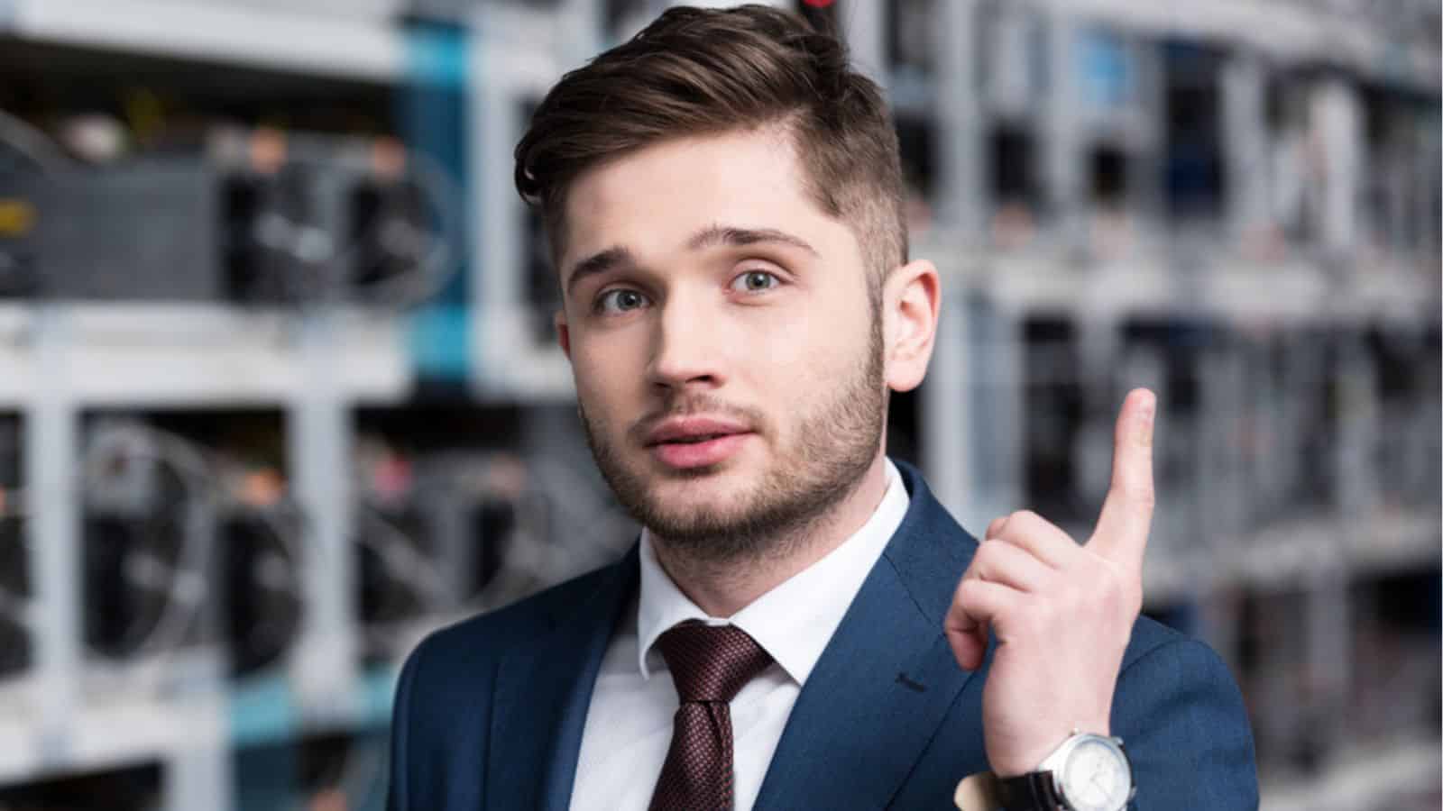 Handsome young businessman with creative idea pointing up