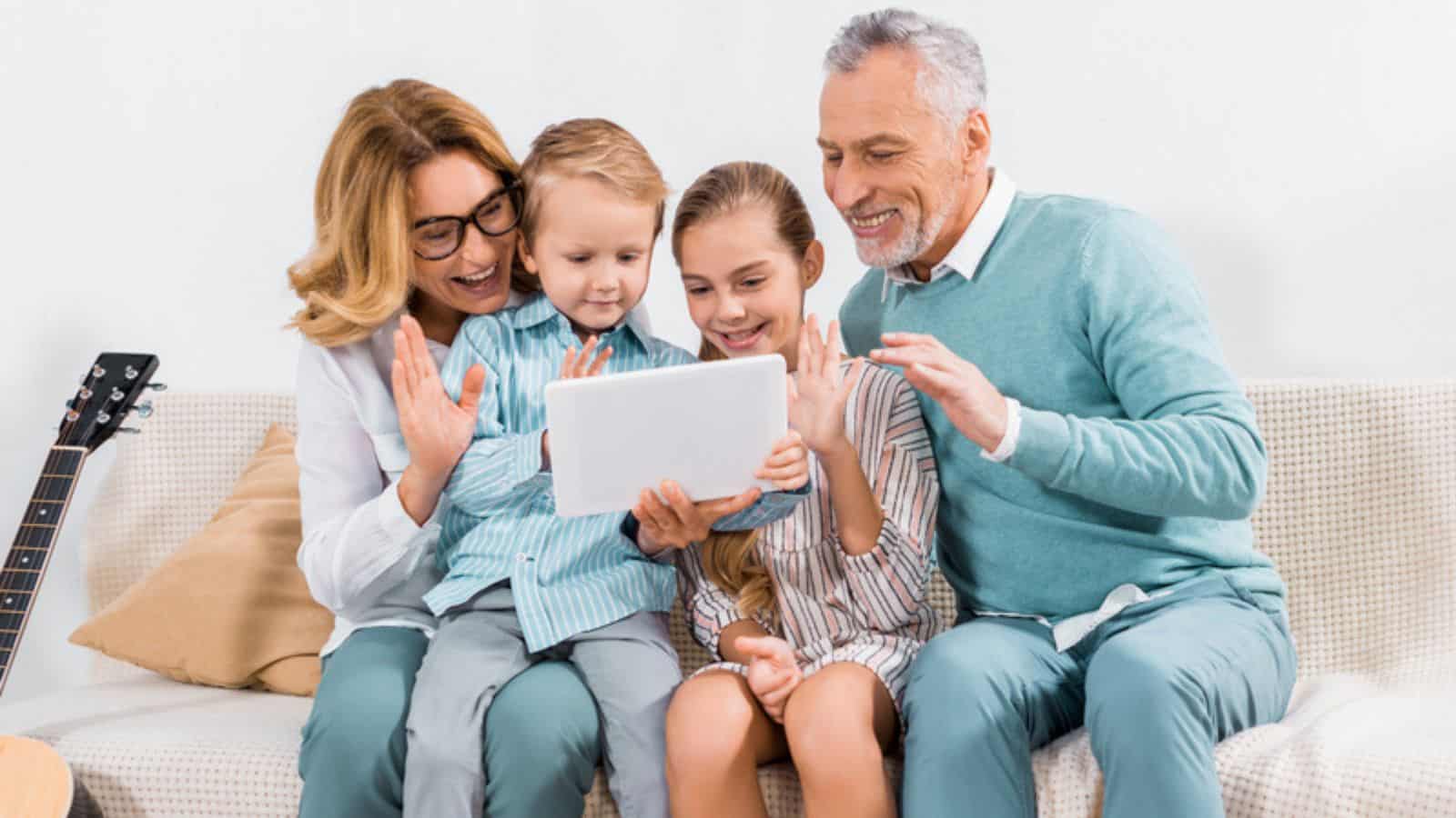 Happy family waving by hands while having video call