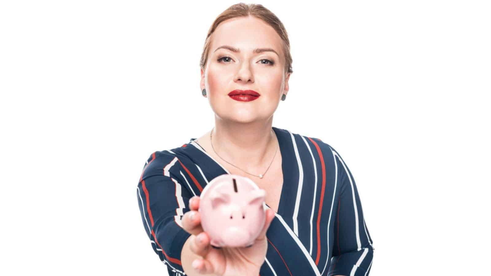 Happy female accountant giving pink piggy bank
