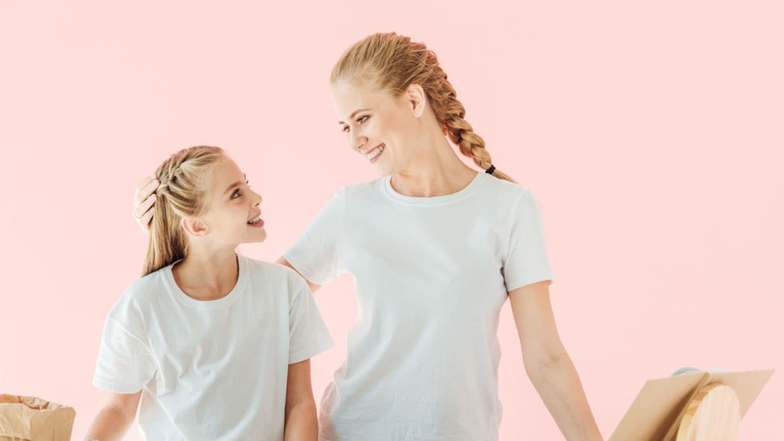 appy mother and daughter in white t-shirts looking at each other