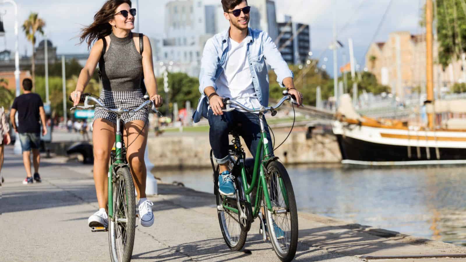 Happy young couple cycling in the city