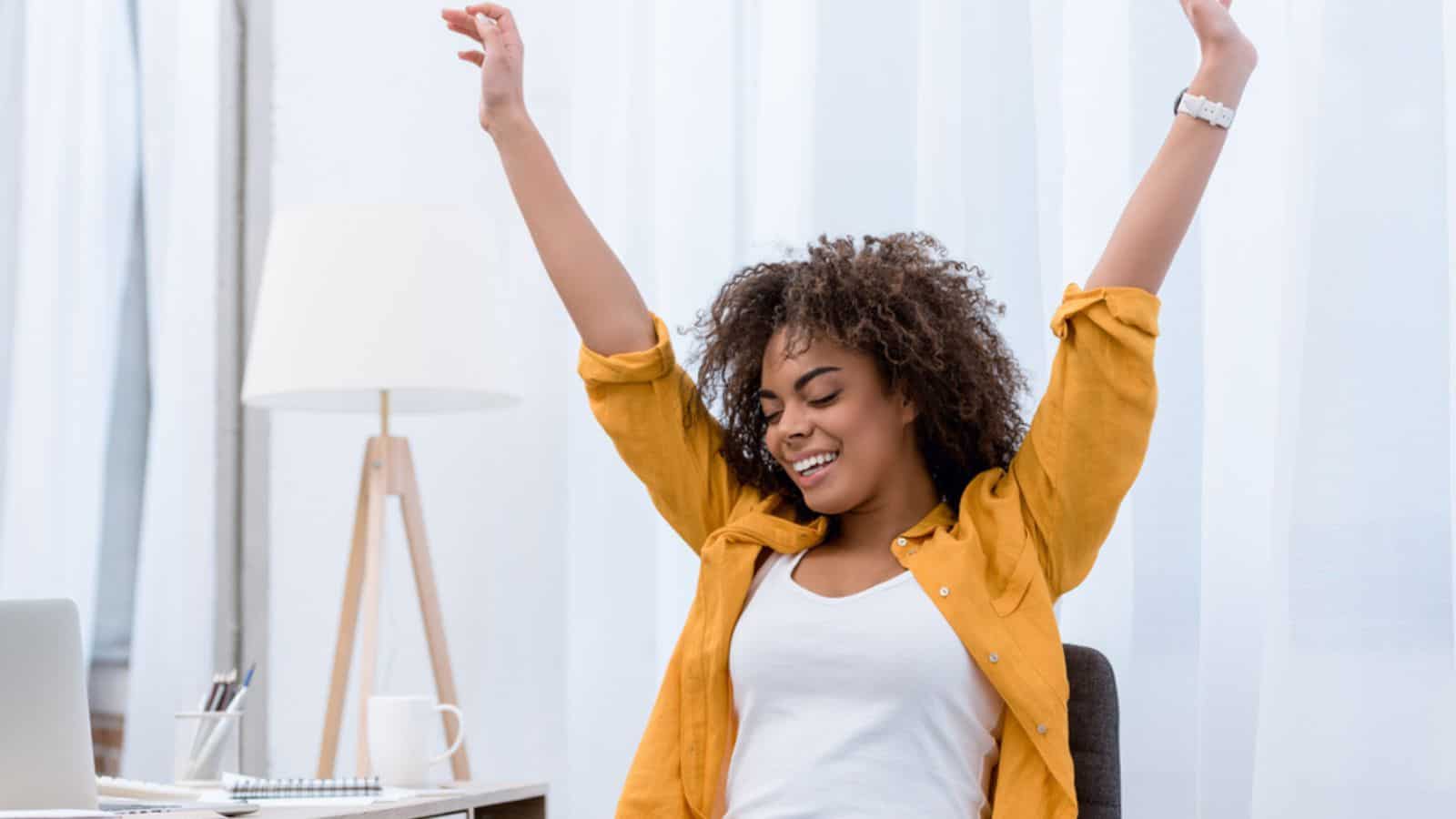 Happy young woman with raised hands