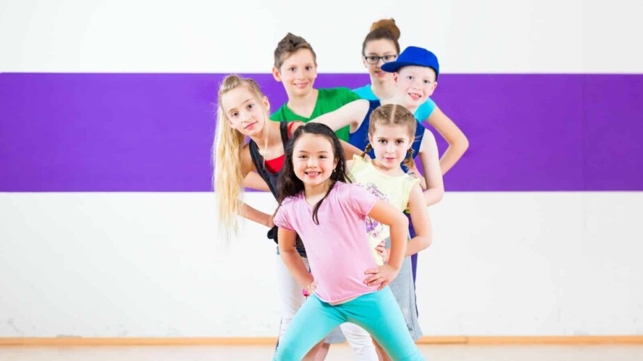 Kids train zumba fitness in dancing school