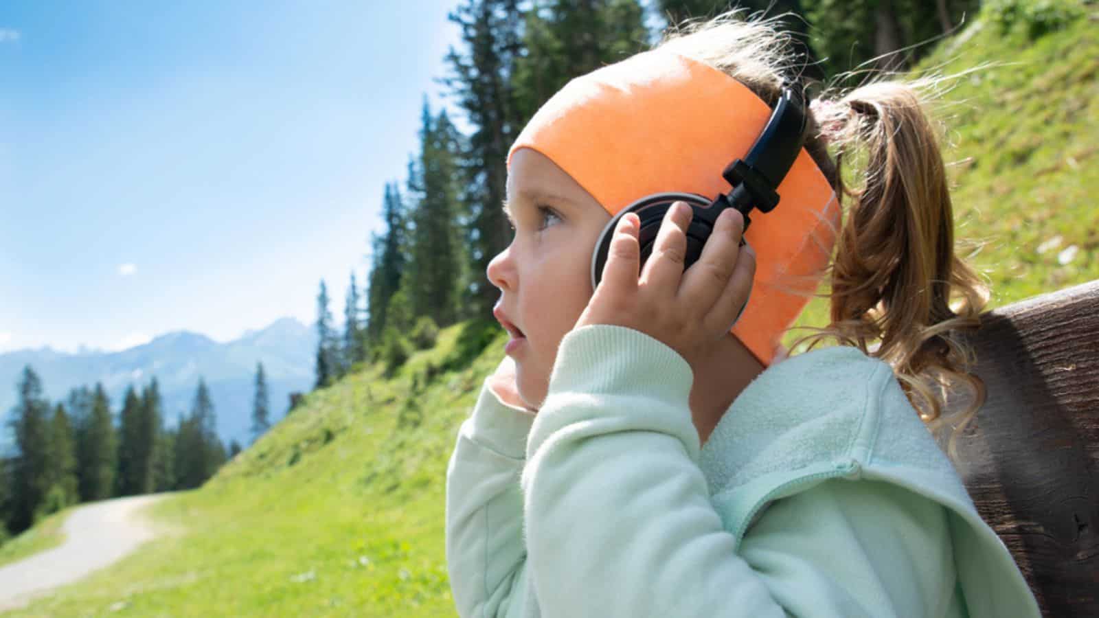 Little Girl In Headphone Listening Music In Mountains