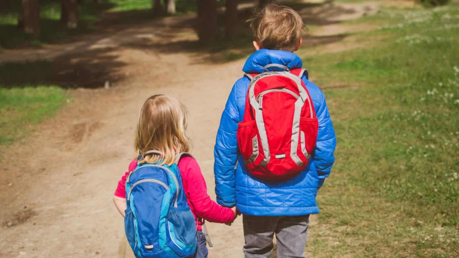 Little boy and girl with backpacks going to hiking