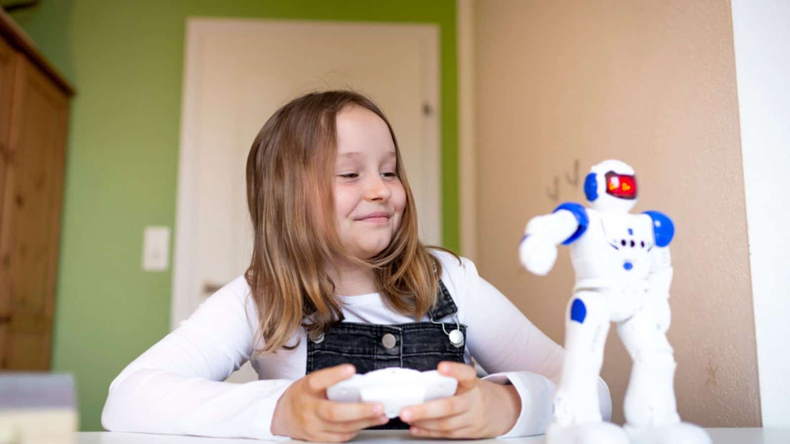 Little boy is playing with robot