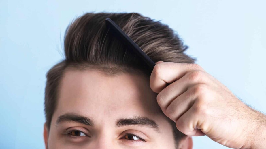 Man Combing Hair on Color Background