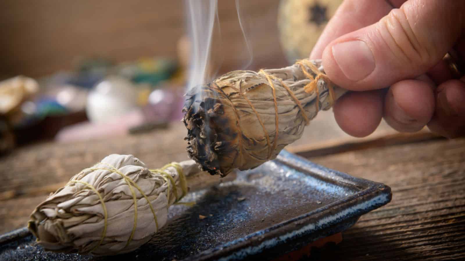 Man burning white sage incense
