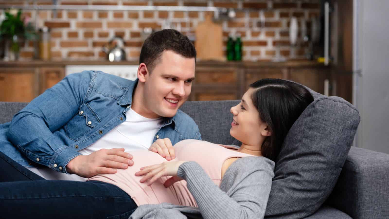 Man touching belly of pregnant wife