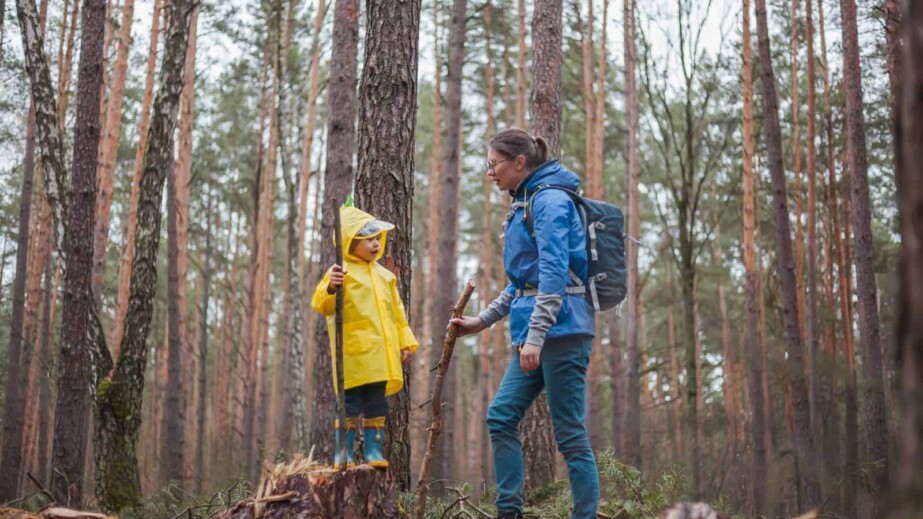 Mom and Child with Raincoat Walking in the Forest