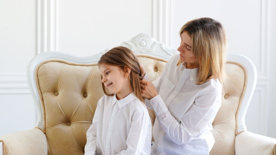Mother Fixing Daughter's Hair Indoors
