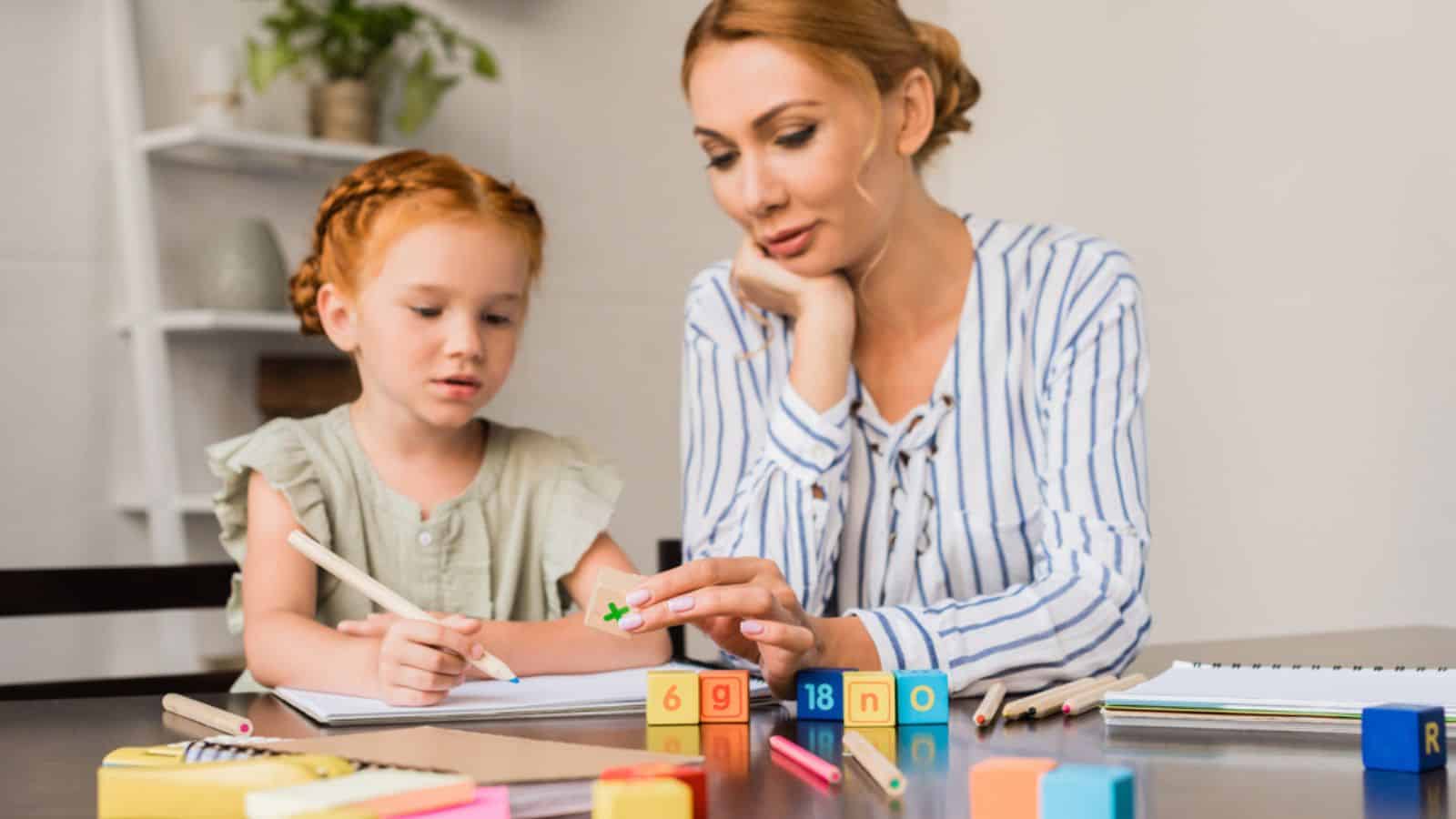 Mother and daughter learning math with cubes