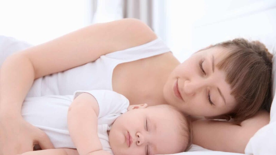 Mother sleeping with newborn baby