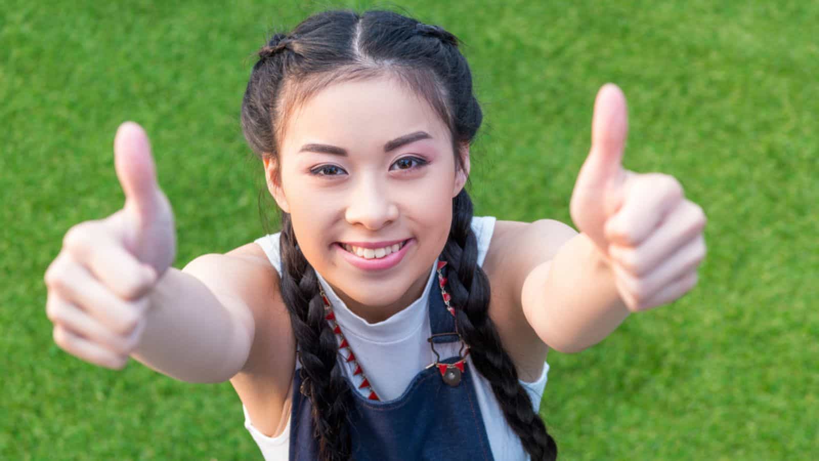 New Asian girl showing thumbs up