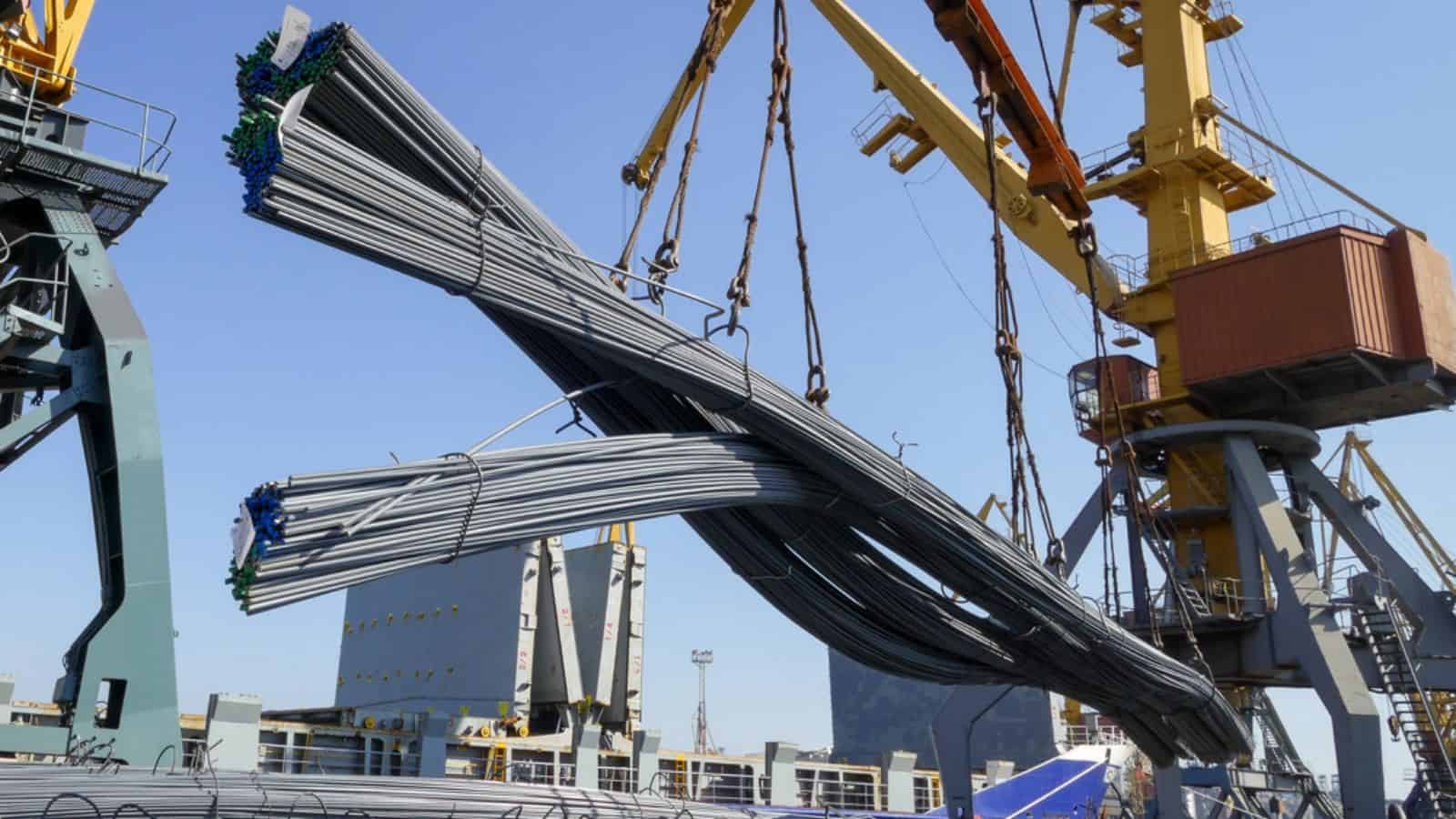 Port crane loads building reinforcement onto a ship