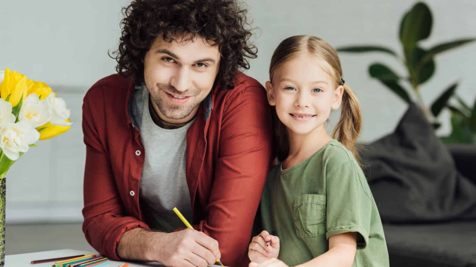 Happy father and daughter drawing together and smiling