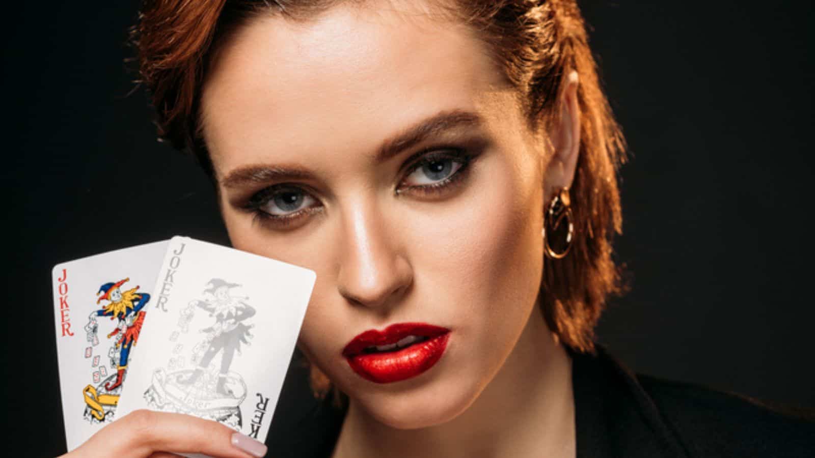 Portrait of attractive girl in red dress and black jacket holding cards
