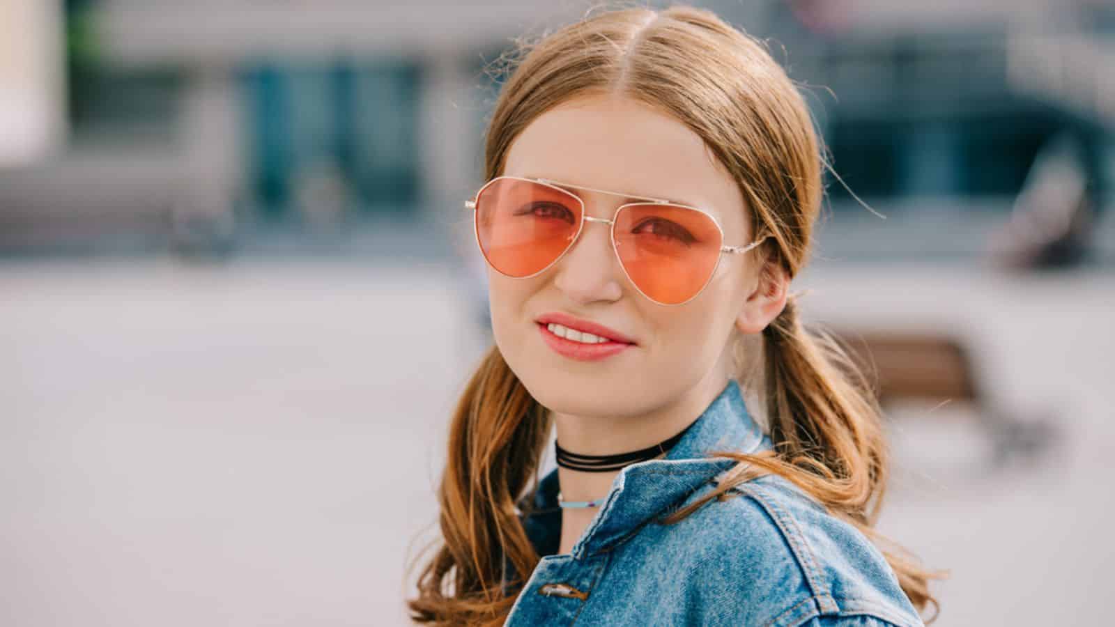 Portrait of beautiful young woman in sunglasses and denim jacket