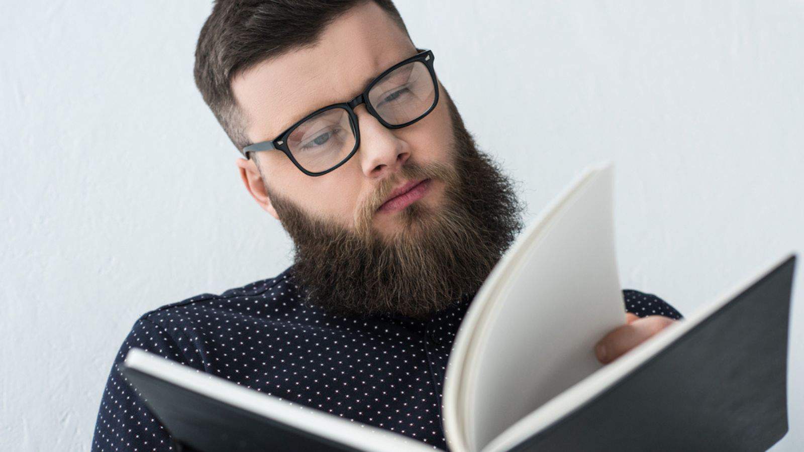 Portrait of focused businessman in eyeglasses reading